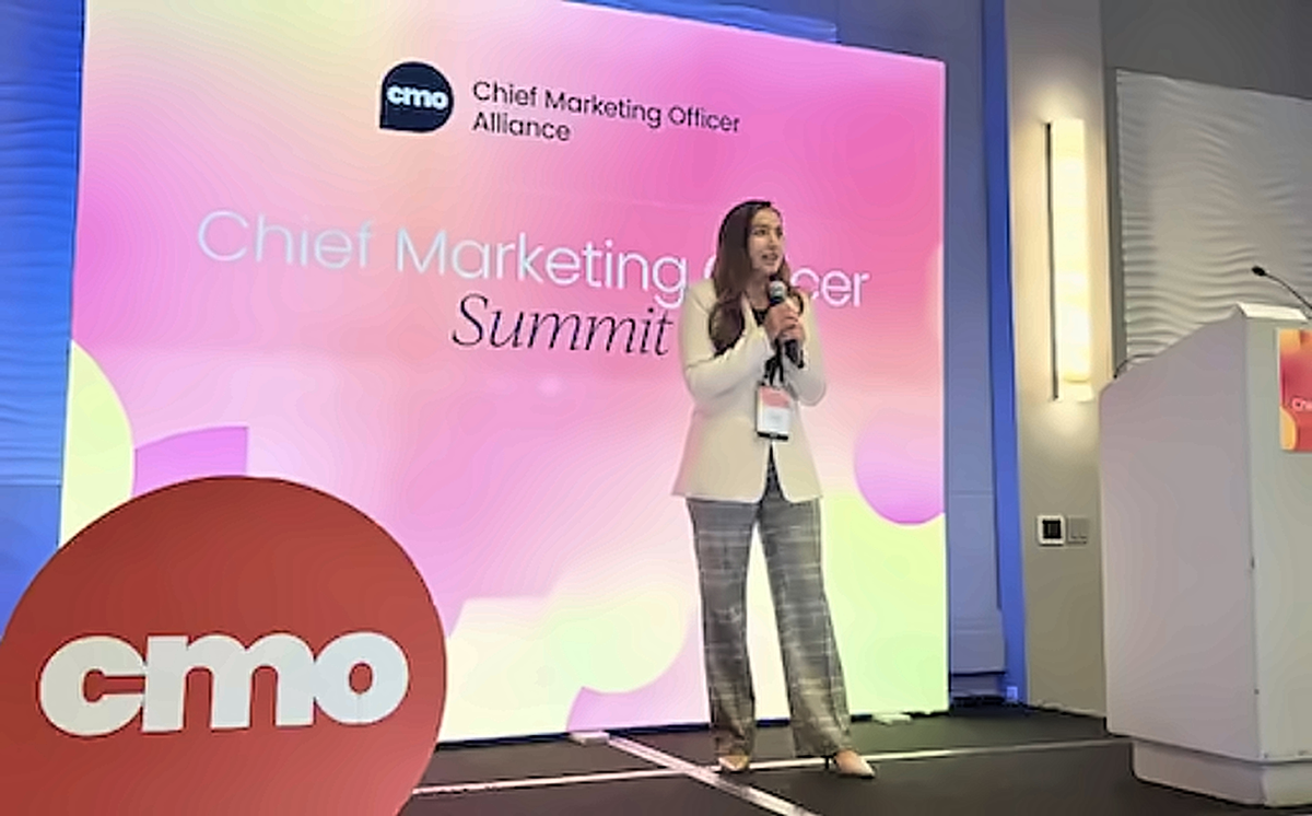 Speaker presenting onstage at the CMO Alliance Summit, where marketing leaders discussed AI adoption challenges and organizational integration.